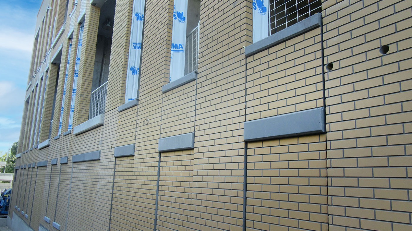Close view of light brick pattern precast with a dark banding course, cast on seamless liners